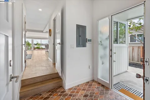 a view of a hallway with wooden floor and windows