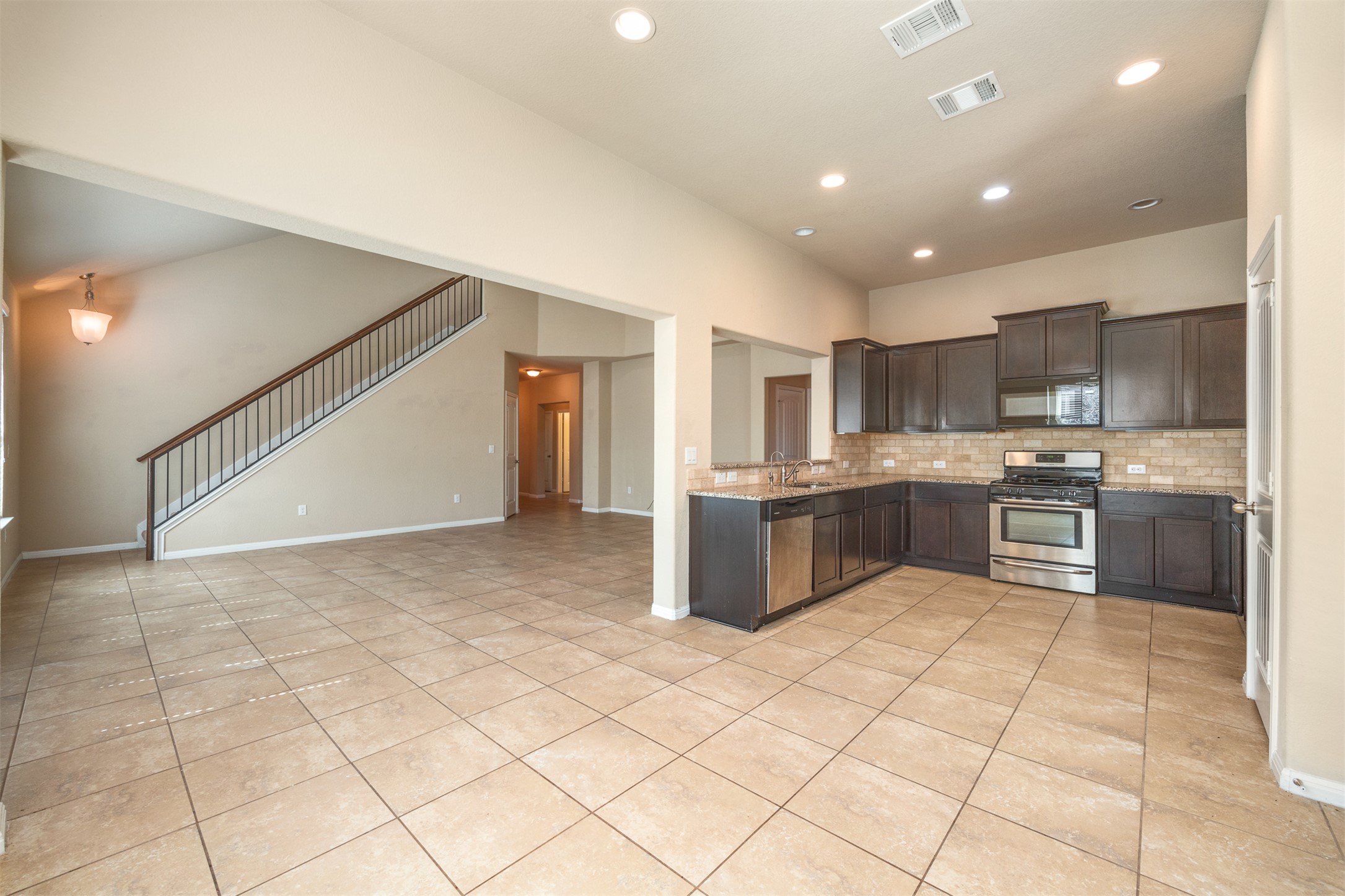 125 Serrano Street Georgetown, TX 78628 - Photo 18 of 18 a kitchen with a sink a counter top space cabinets and stainless steel appliances