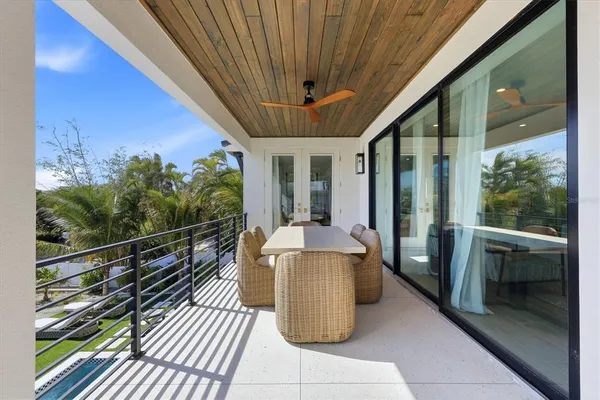 a view of a patio with table and chairs potted plants and floor to ceiling window