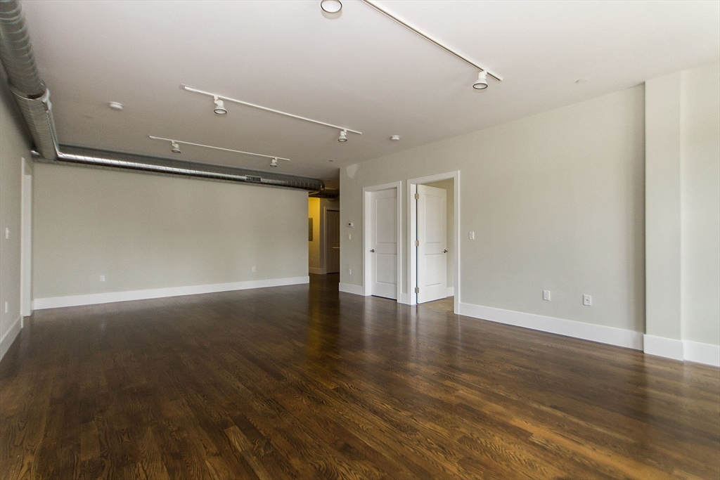 10 St George Street, Unit 406 Boston, MA 02118 - Photo 4 of 11 a view of an empty room with wooden floor and a window