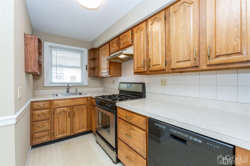 642 Front Street Dunellen, NJ 08812 - Photo 11 of 24 a kitchen with stainless steel appliances granite countertop a sink a stove and a microwave