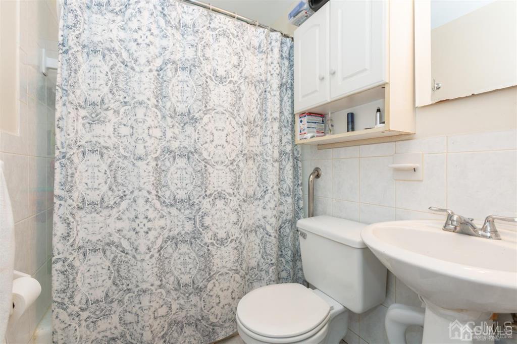 642 Front Street Dunellen, NJ 08812 - Photo 24 of 24 a white toilet sitting next to a bathroom sink