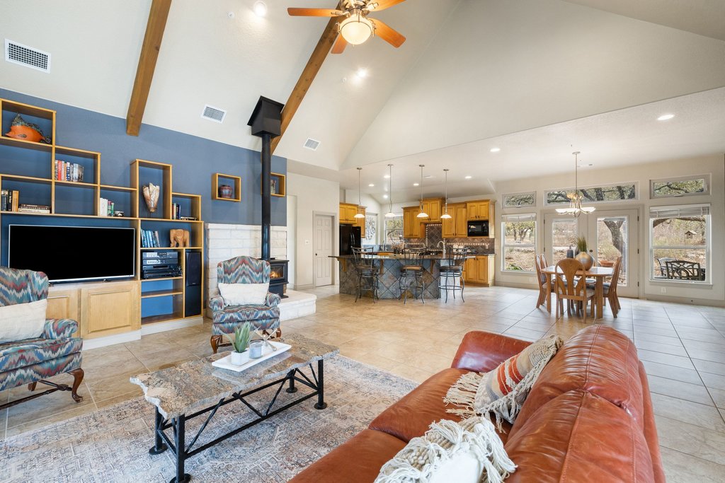 232 Crooked Oak Round Mountain, TX 78663 - Photo 9 of 40 Living area with a wood stove, high vaulted ceiling, recessed lighting, light tile patterned flooring, and ceiling fan