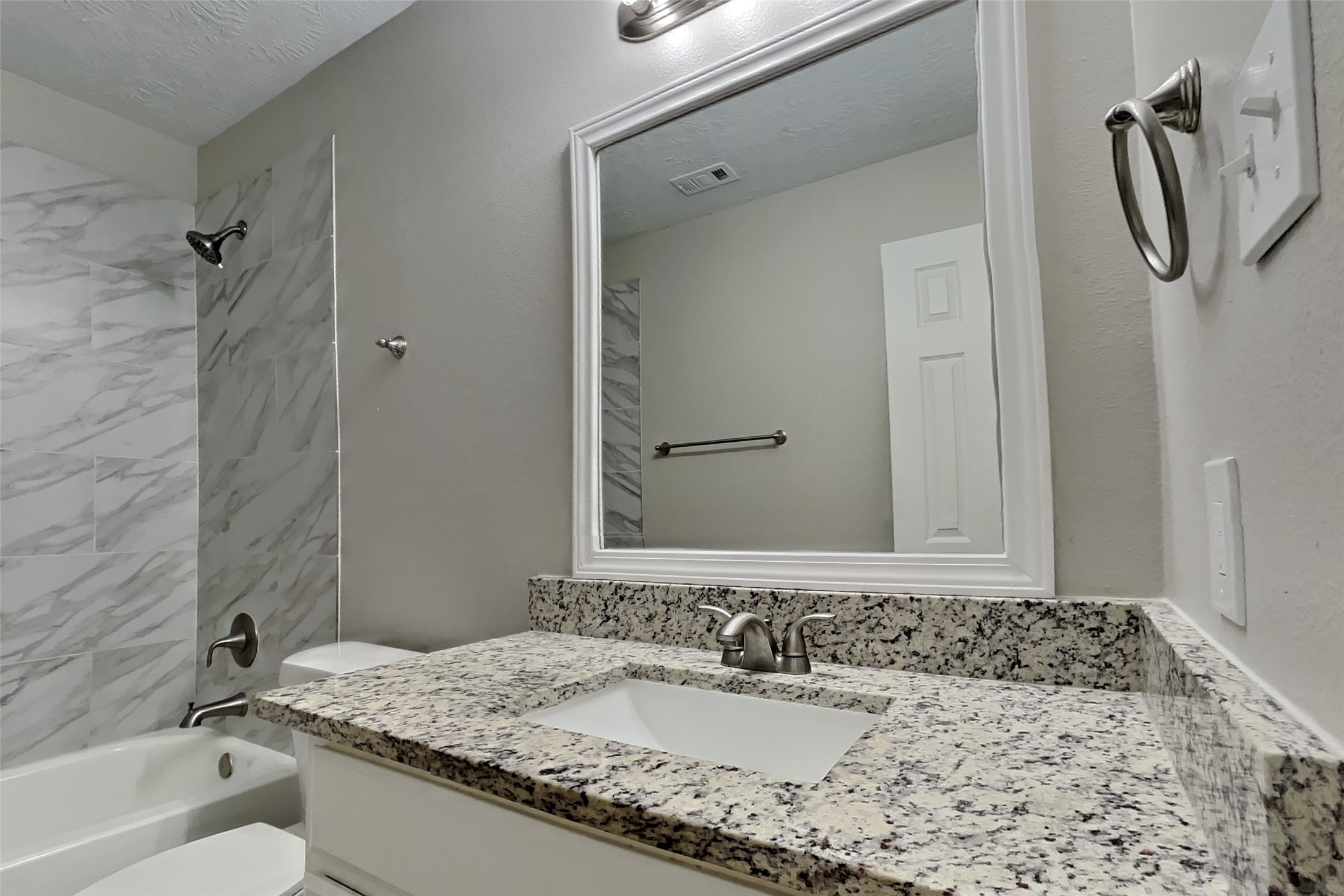 4938 Comal River Loop Spring, TX 77386 - Photo 13 of 14 a bathroom with a granite countertop sink and a mirror a bathtub