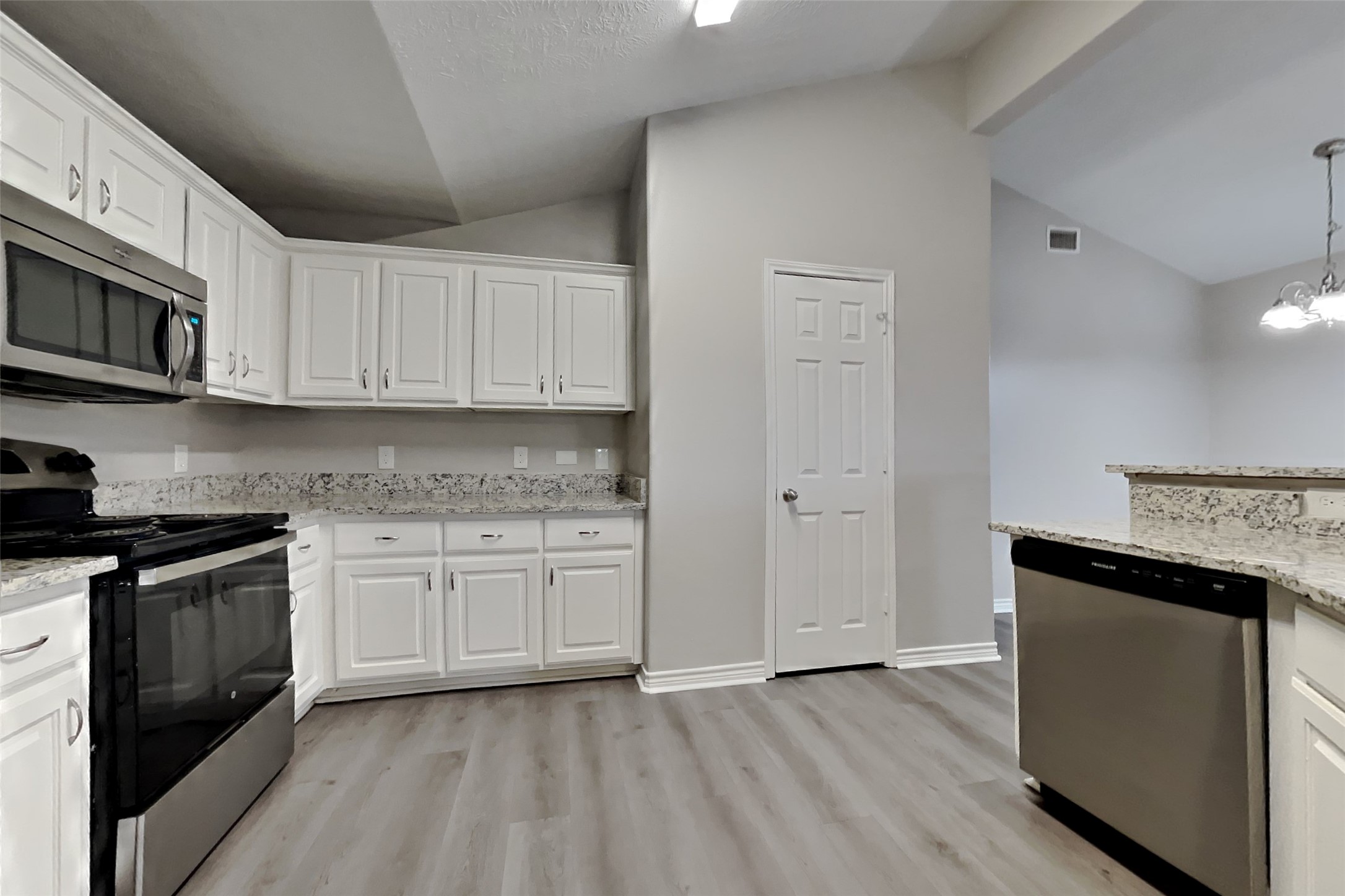 4938 Comal River Loop Spring, TX 77386 - Photo 4 of 14 a kitchen with stainless steel appliances granite countertop a stove a sink and a microwave