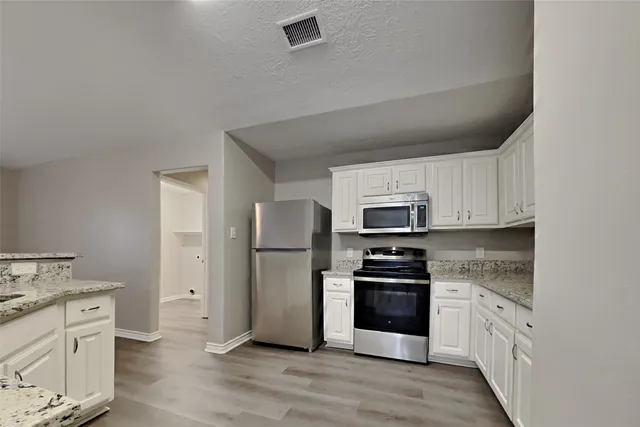 a kitchen with a refrigerator stove and sink