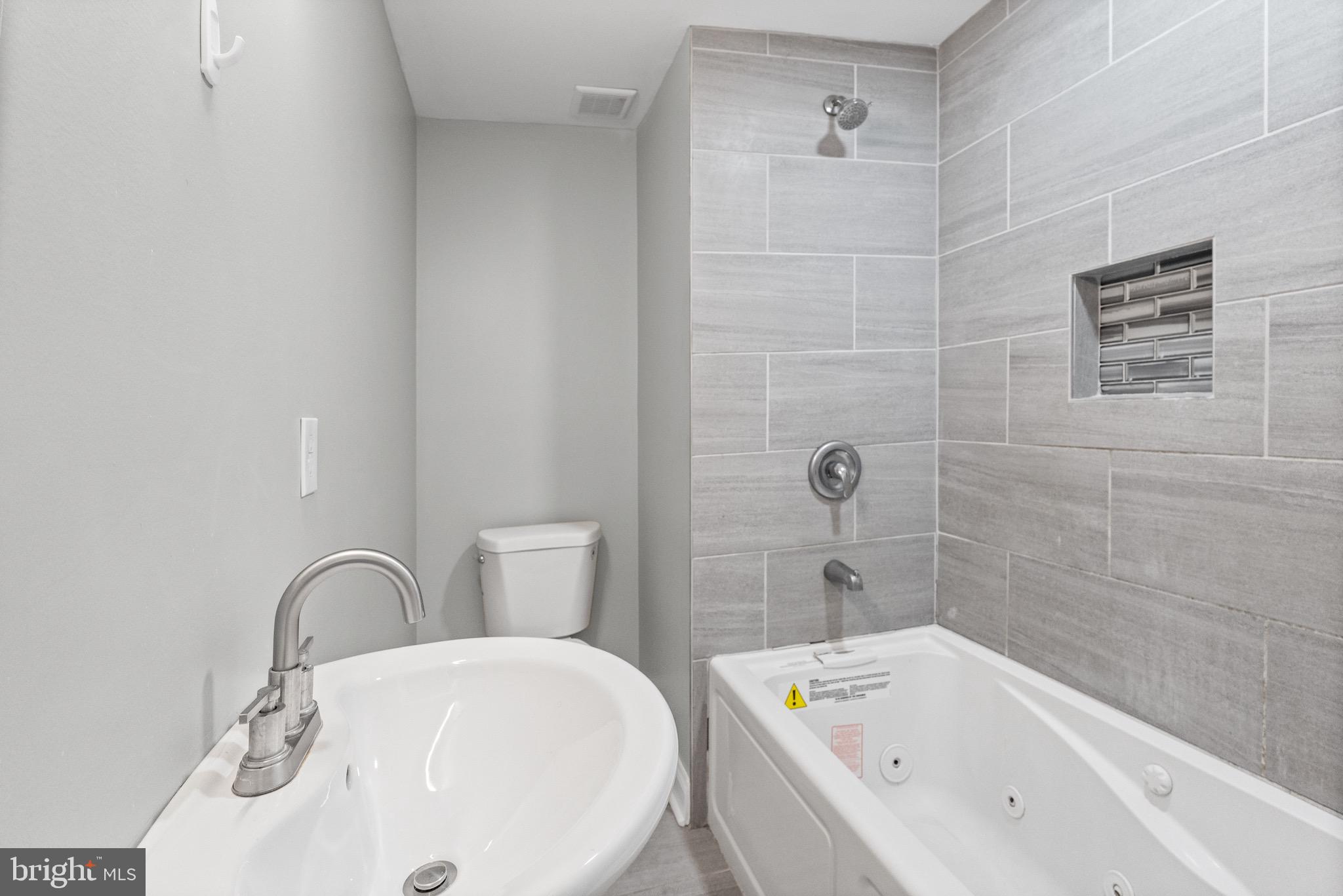 4139 Mountwood Road Baltimore, MD 21229 - Photo 11 of 53 a bathroom with a bathtub and shower