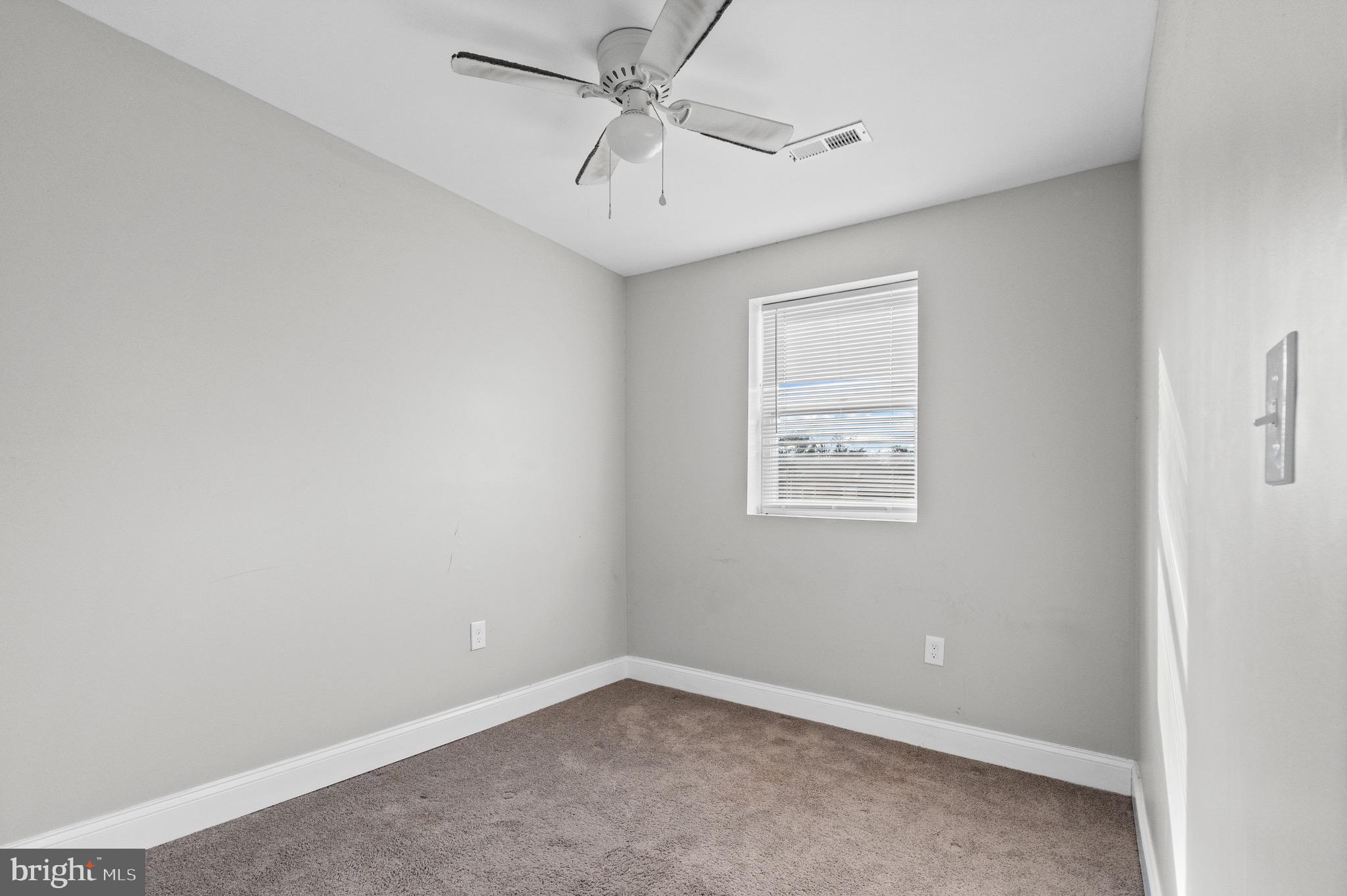 4139 Mountwood Road Baltimore, MD 21229 - Photo 14 of 53 an empty room with windows and fan