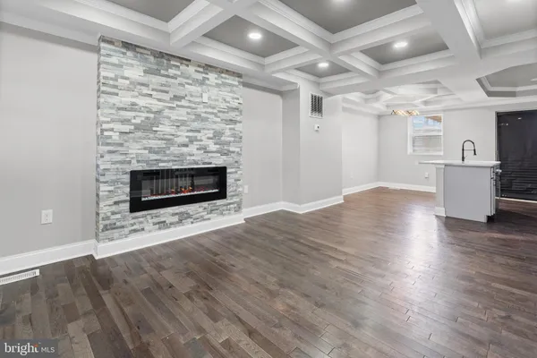 an empty room with wooden floor fireplace and windows