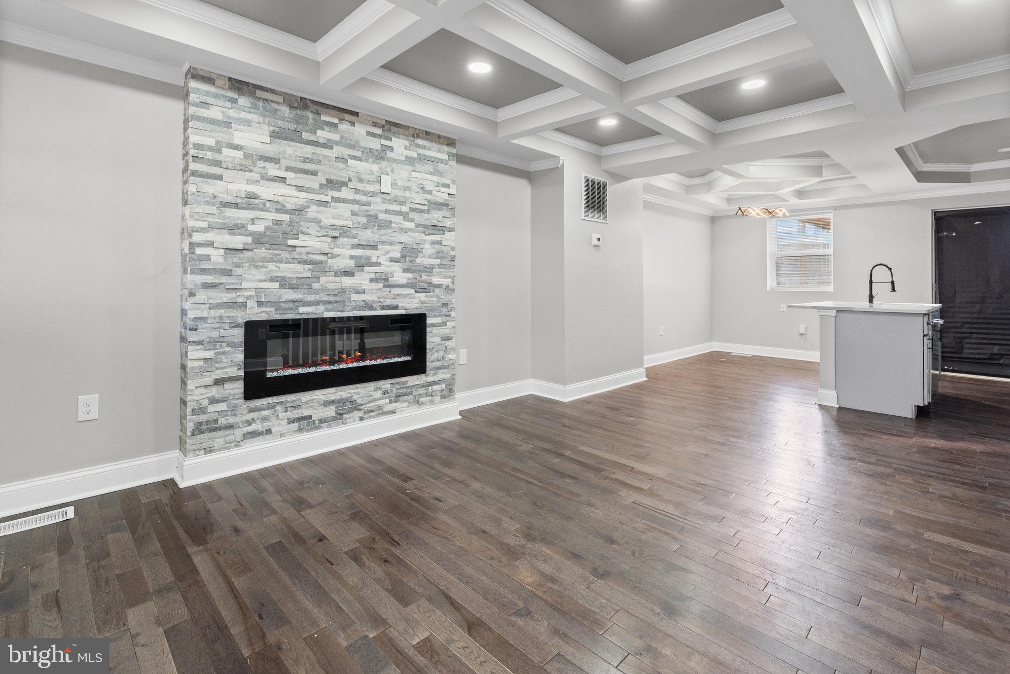 4139 Mountwood Road Baltimore, MD 21229 - Photo 2 of 53 an empty room with wooden floor fireplace and windows
