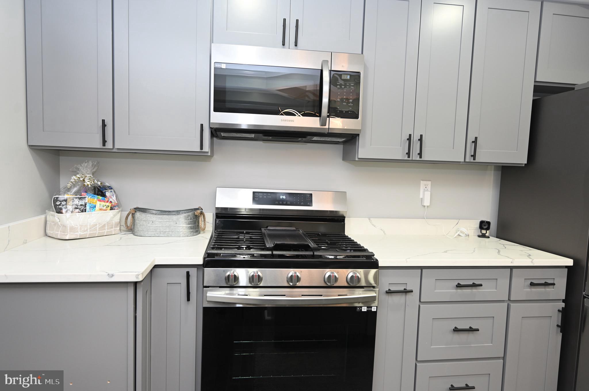 4139 Mountwood Road Baltimore, MD 21229 - Photo 27 of 53 a kitchen with stainless steel appliances granite countertop white cabinets a stove top oven and dishwasher