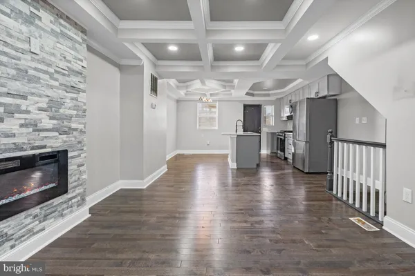 a view of a livingroom with wooden floor and a kitchen