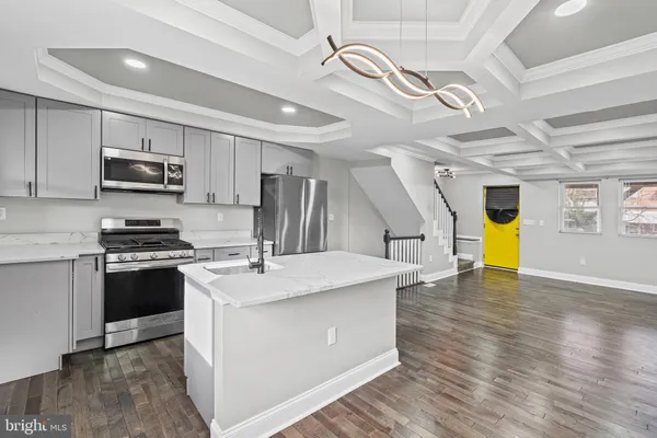 a kitchen with stainless steel appliances kitchen island granite countertop a stove a sink and a refrigerator