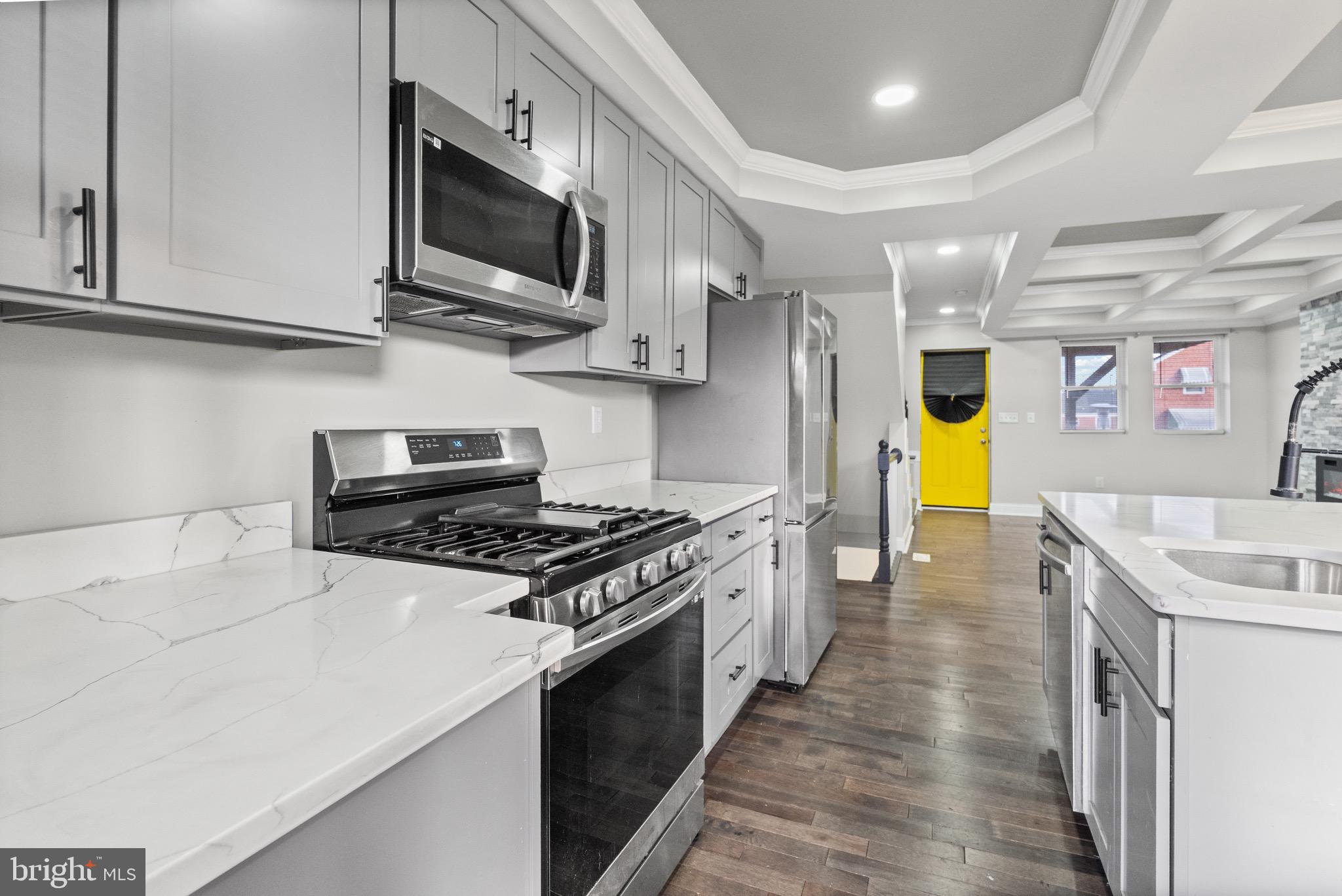 4139 Mountwood Road Baltimore, MD 21229 - Photo 6 of 53 a kitchen with stainless steel appliances granite countertop a sink a stove top oven a chimney wooden cabinets and floors