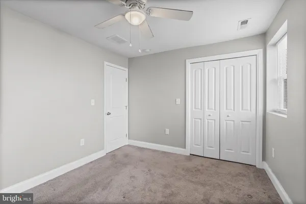 an empty room with a chandelier fan