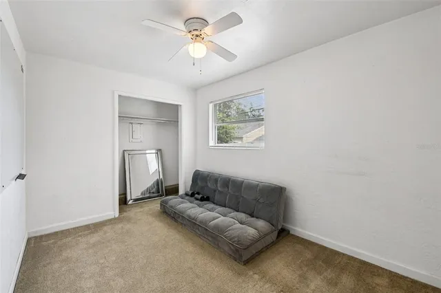a living room with furniture and a ceiling fan