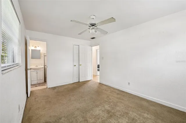 an empty room with fan and windows
