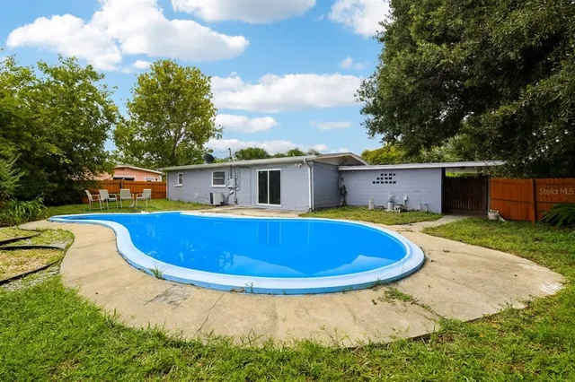 a view of a house with swimming pool and yard