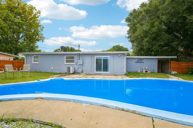 a view of an house with swimming pool and a yard
