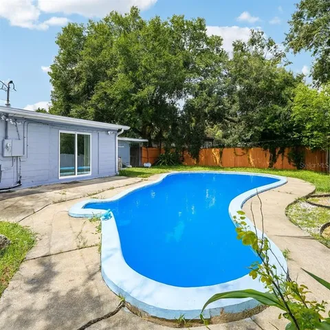 a view of a backyard with swimming pool