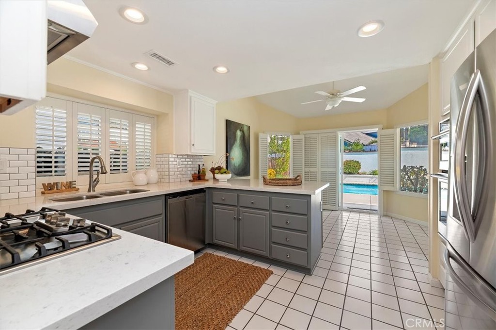 43966 Highlander Drive Temecula, CA 92592 - Photo 7 of 33 a kitchen with stainless steel appliances a stove a sink a refrigerator and cabinets