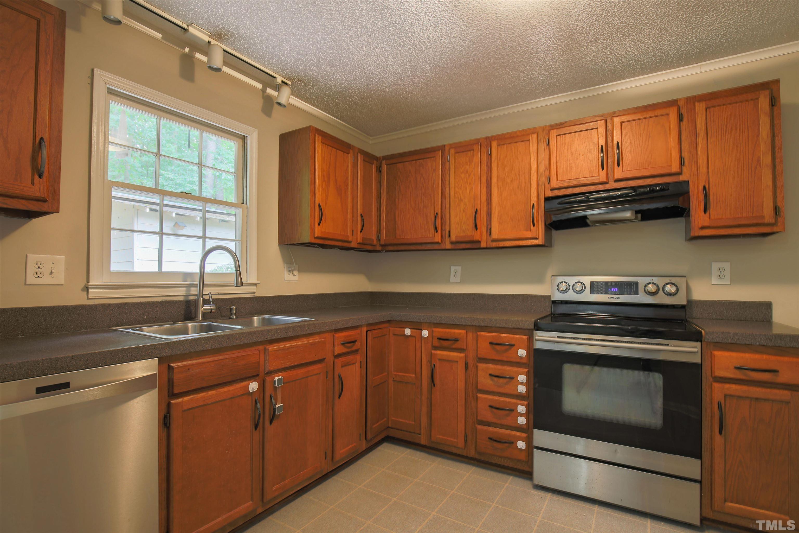 7712 Cart Track Trail Raleigh, NC 27615 - Photo 2 of 11 a kitchen with granite countertop a sink stainless steel appliances and cabinets