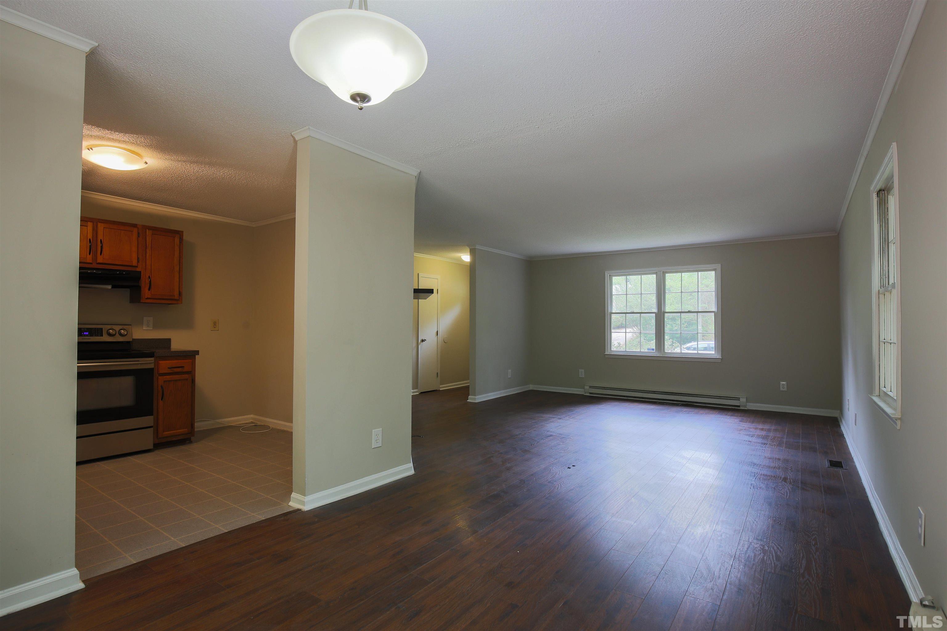 7712 Cart Track Trail Raleigh, NC 27615 - Photo 4 of 11 an empty room with wooden floor and windows