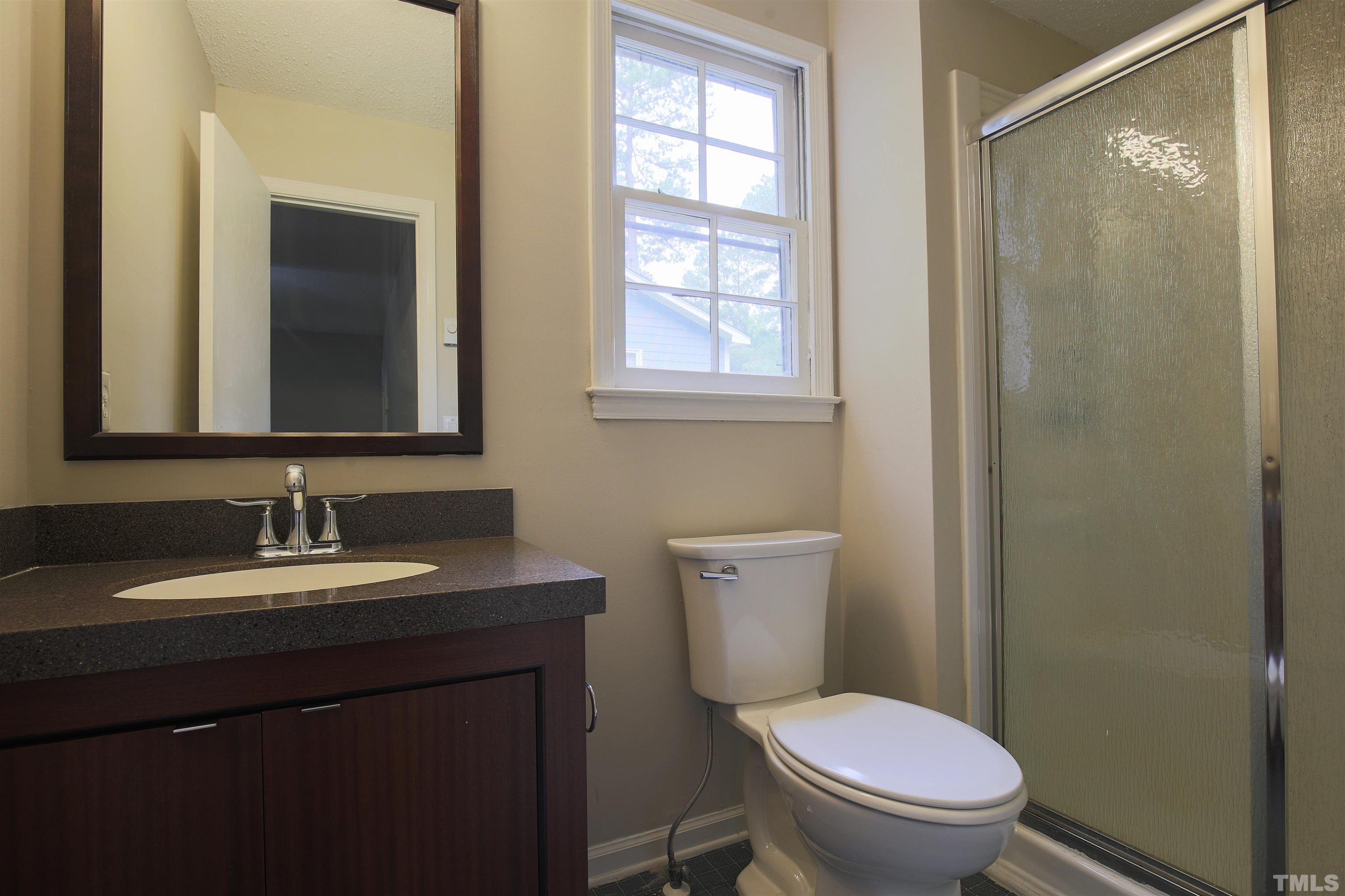 7712 Cart Track Trail Raleigh, NC 27615 - Photo 7 of 11 a bathroom with a toilet a sink and mirror