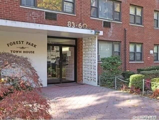 83-60 118th Street, Unit 12E Queens, NY 11415 - Photo 1 of 1 a view of a brick building with potted plants in front of door
