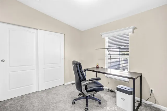 a view of a workspace with furniture and a window