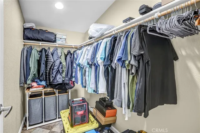 a view of walk in closet with clothes and shoes