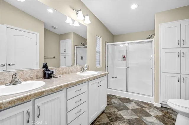 a spacious bathroom with a double vanity sink mirror and toilet