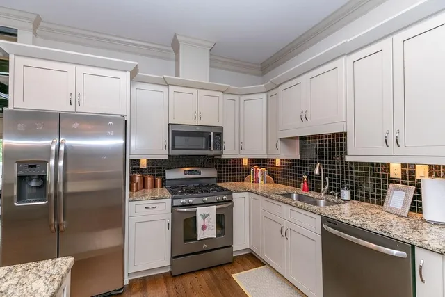 a kitchen with granite countertop a refrigerator stove and microwave