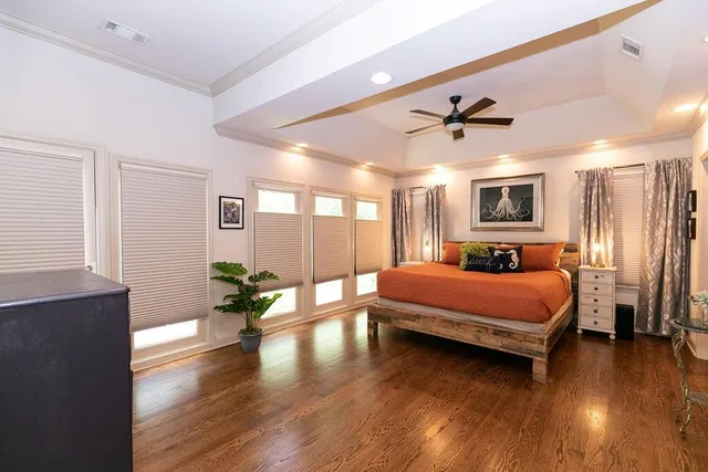 a spacious bedroom with a balcony a bed and wooden floor