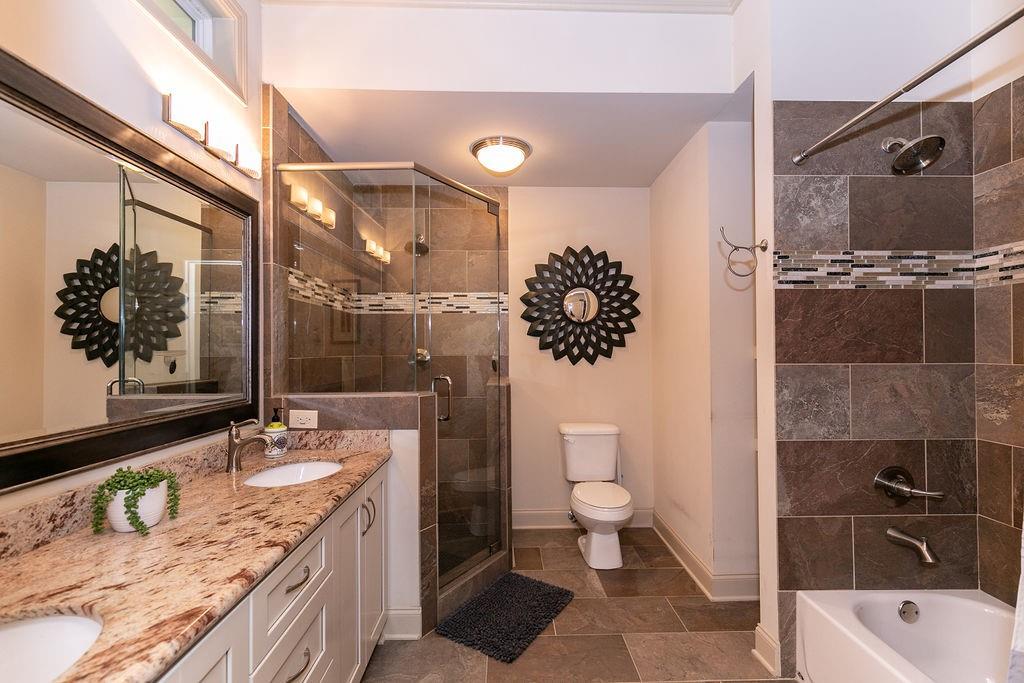 1084 Sanders Avenue Southeast, Unit A Atlanta, GA 30316 - Photo 37 of 44 a bathroom with a granite countertop sink a toilet and shower