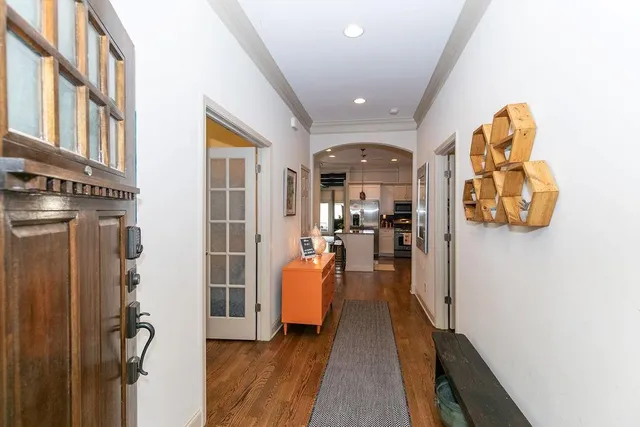 a view of a hallway with wooden floor and furniture