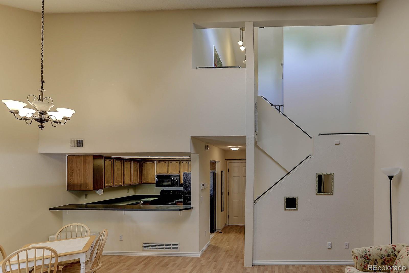 8794 Allison Drive, Unit B Arvada, CO 80005 - Photo 16 of 33 a kitchen with stainless steel appliances granite countertop a refrigerator a stove and a sink with wooden floor