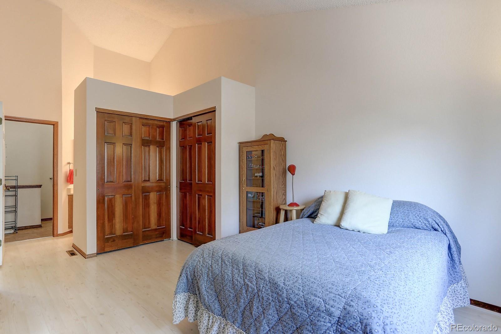 8794 Allison Drive, Unit B Arvada, CO 80005 - Photo 19 of 33 a bedroom with a large bed and wooden floor