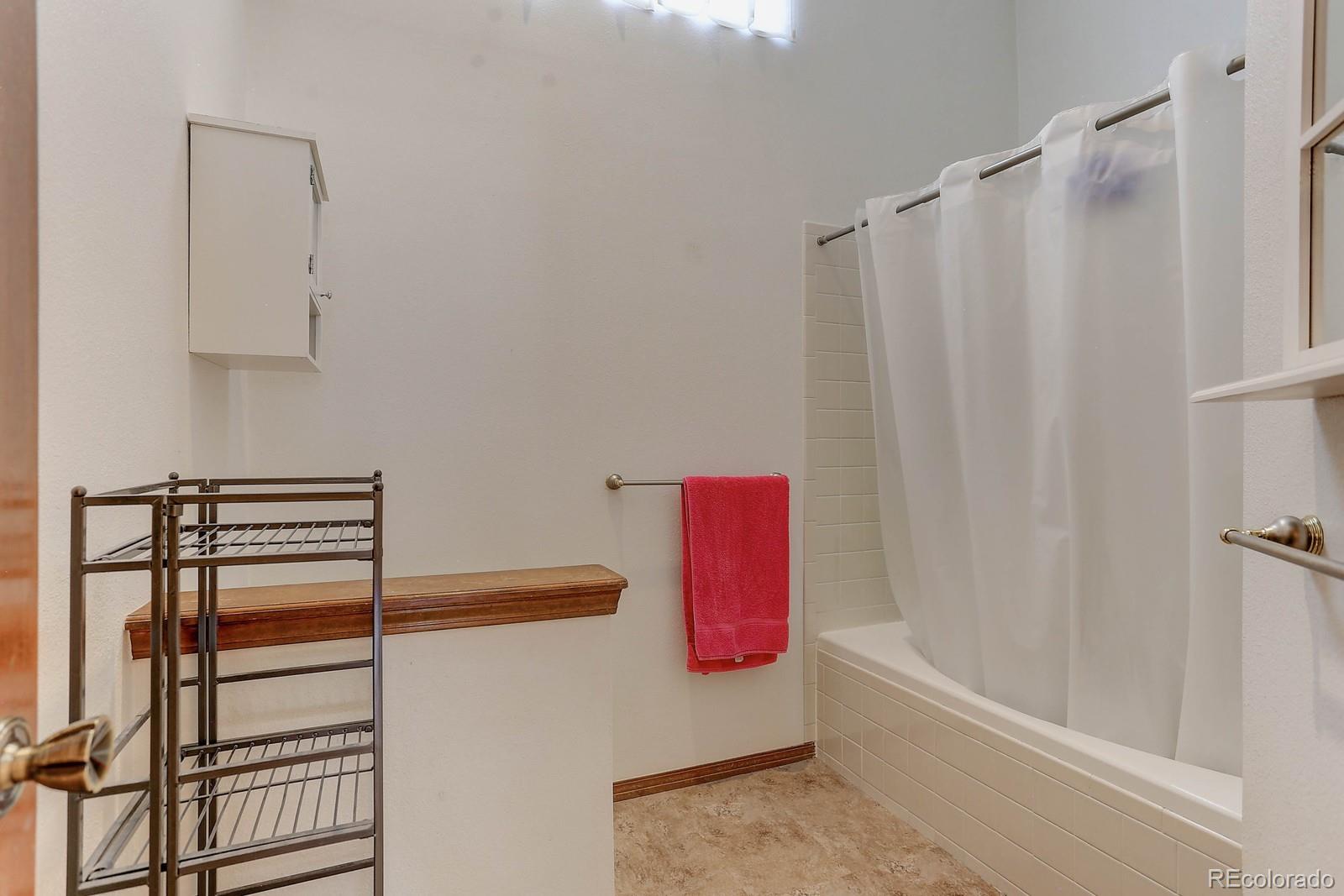 8794 Allison Drive, Unit B Arvada, CO 80005 - Photo 23 of 33 a bathroom with a shower curtain and a sink