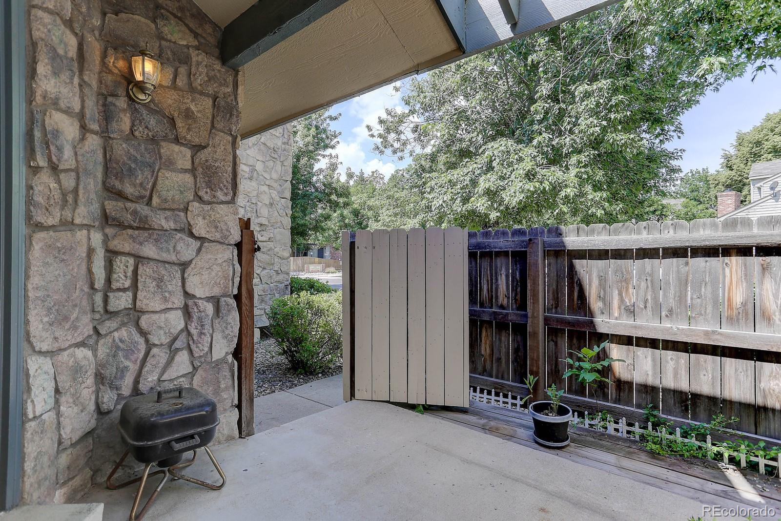 8794 Allison Drive, Unit B Arvada, CO 80005 - Photo 26 of 33 a backyard of a house with lawn chairs and wooden fence