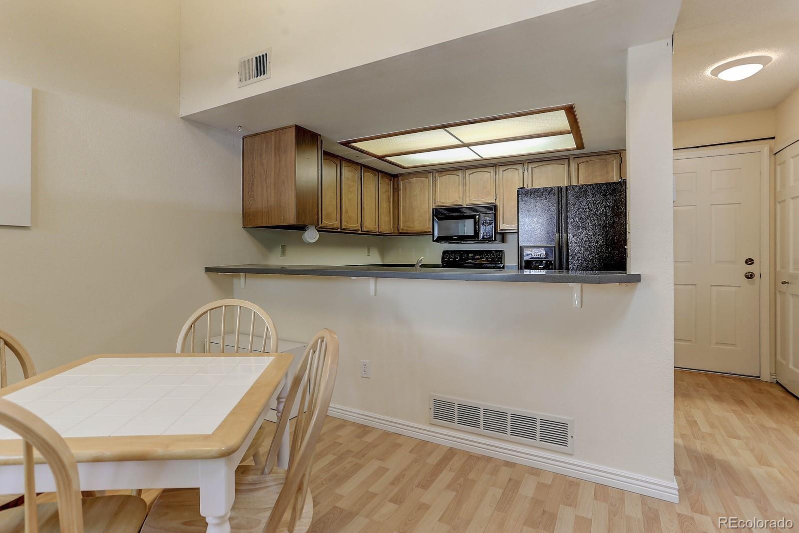 8794 Allison Drive, Unit B Arvada, CO 80005 - Photo 6 of 33 a kitchen with stainless steel appliances a microwave a sink and cabinets