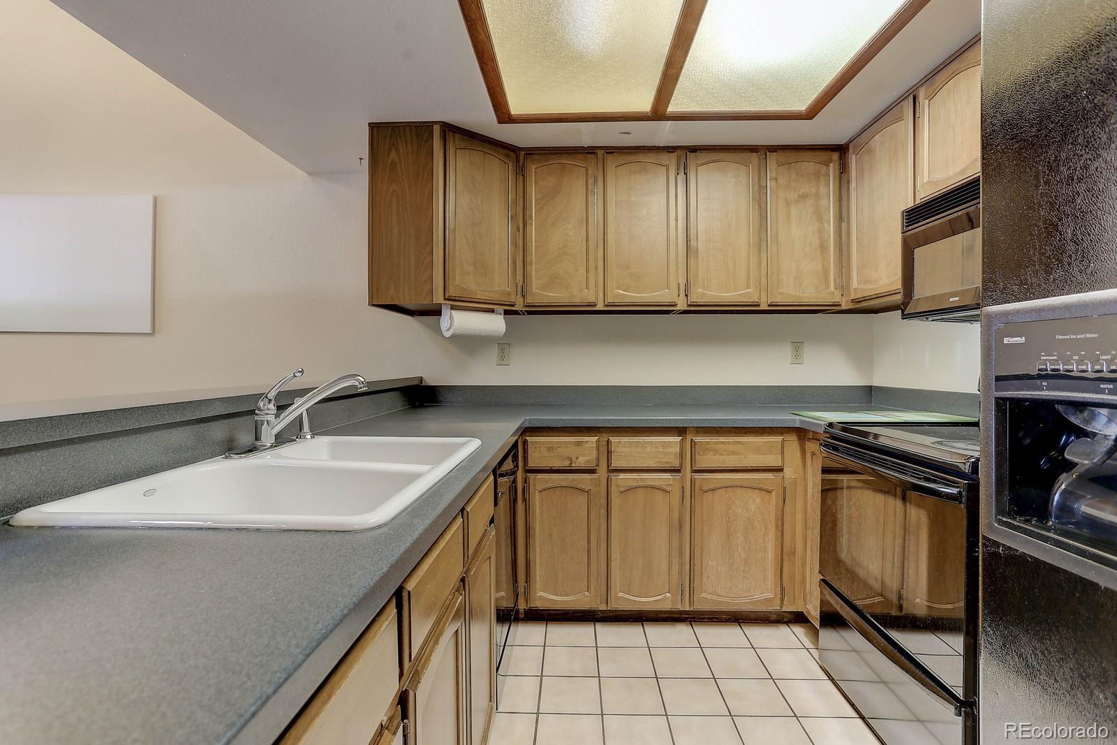 8794 Allison Drive, Unit B Arvada, CO 80005 - Photo 7 of 33 a kitchen with a sink stove and cabinets