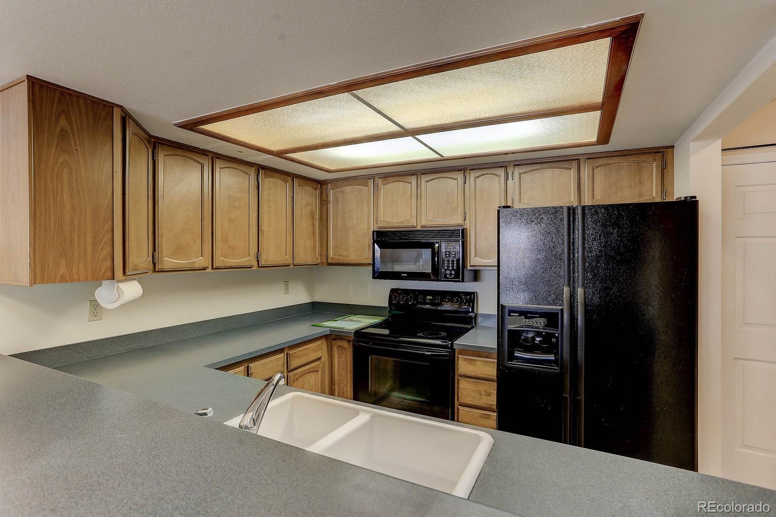 8794 Allison Drive, Unit B Arvada, CO 80005 - Photo 9 of 33 a kitchen with stainless steel appliances a refrigerator and a stove top oven