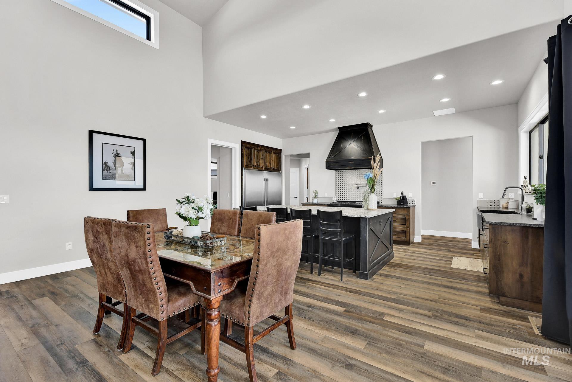 27114 Lower Pleasant Ridge Road Wilder, ID 83676 - Photo 11 of 50 Dining area featuring recessed lighting, dark wood-style floors, and a towering ceiling