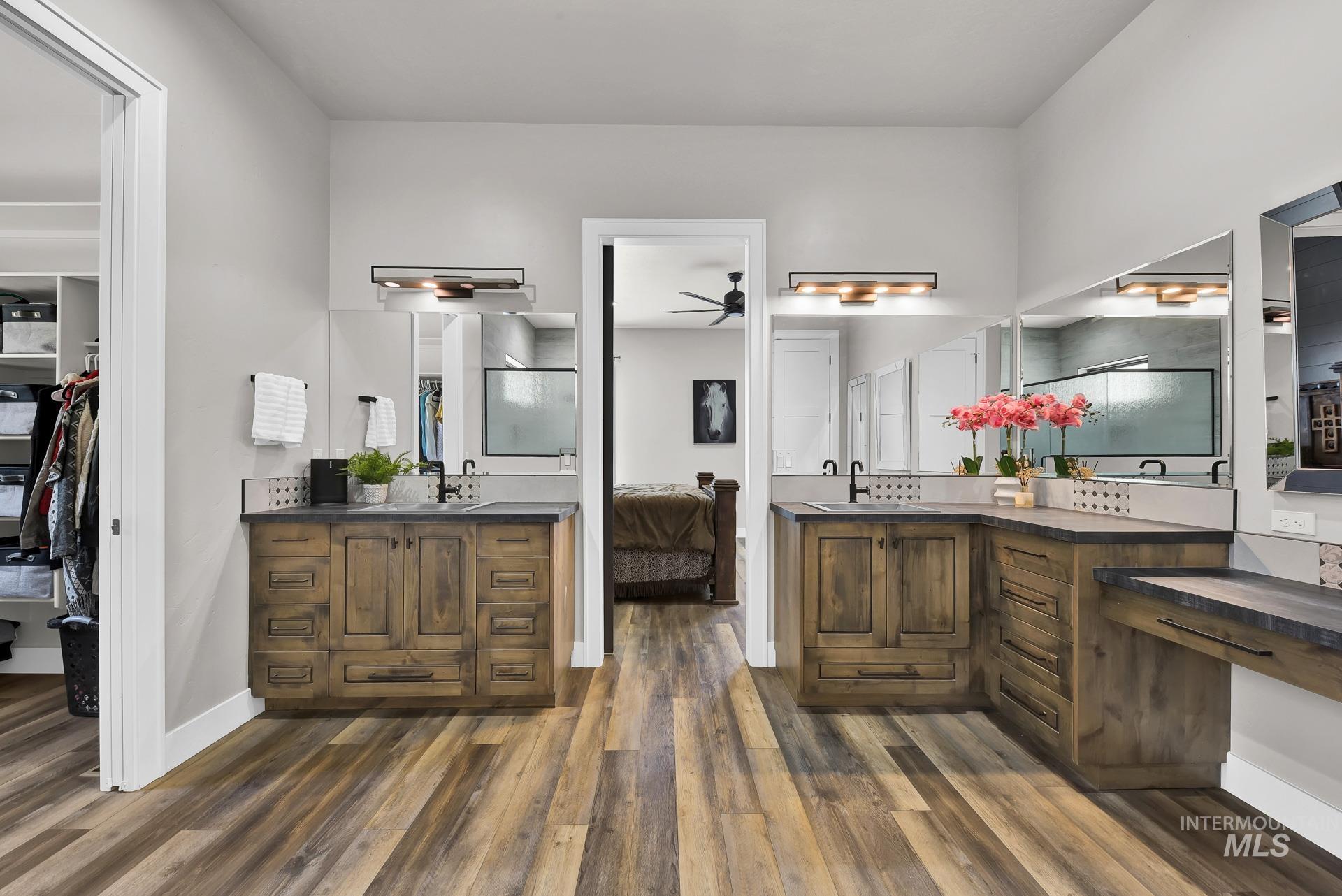 27114 Lower Pleasant Ridge Road Wilder, ID 83676 - Photo 17 of 50 Bathroom featuring a stall shower, wood finished floors, two vanities, a ceiling fan, and ensuite bathroom