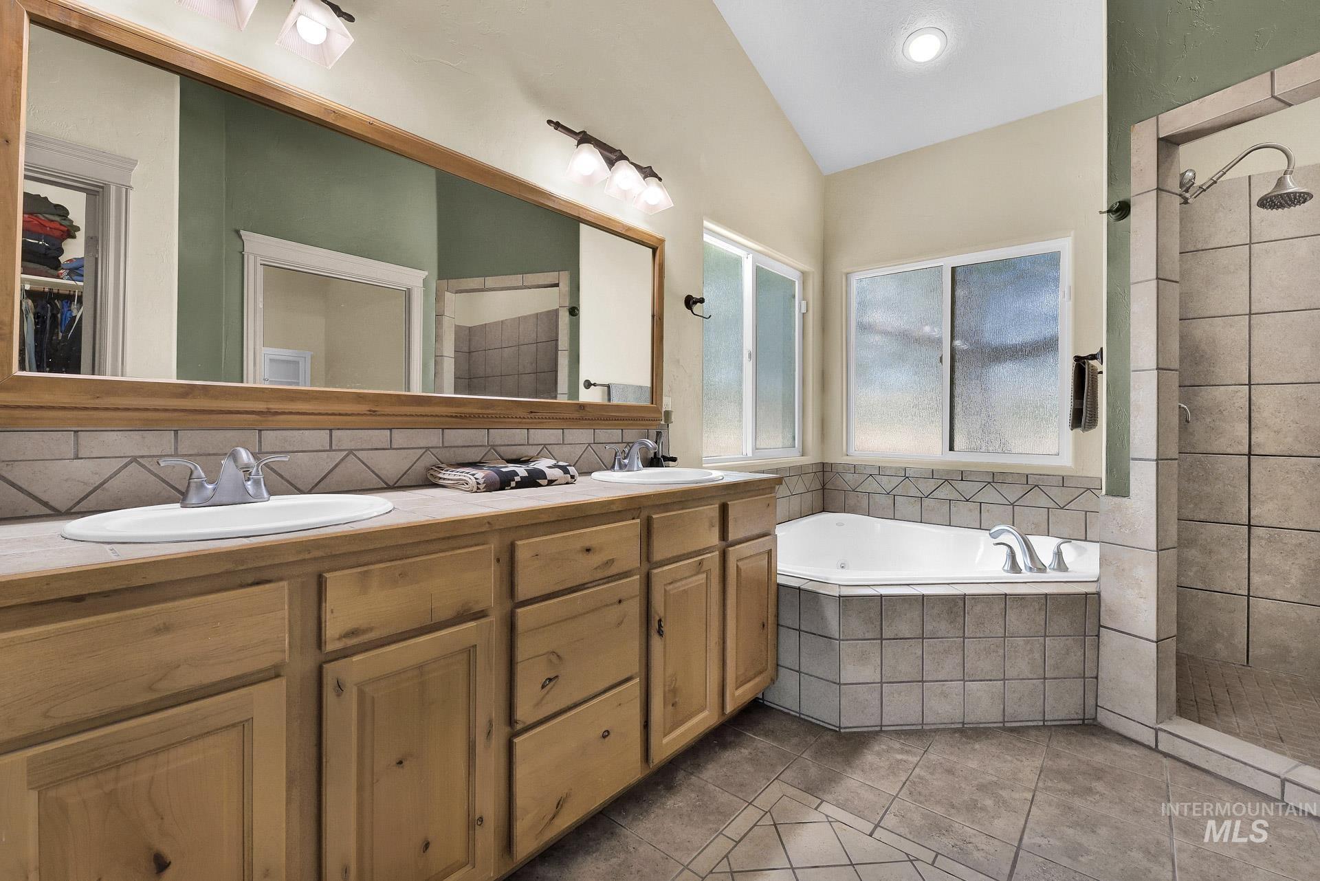 27114 Lower Pleasant Ridge Road Wilder, ID 83676 - Photo 37 of 50 Full bath featuring tile patterned flooring, a garden tub, double vanity, tiled shower, and lofted ceiling