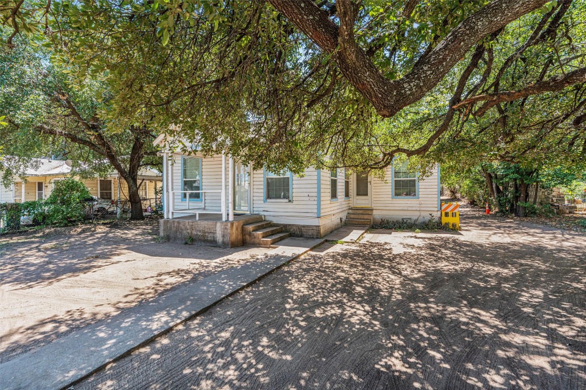 6311 Del Monte Road Austin, TX 78741 - Photo 2 of 24 a backyard of a house with large trees and outdoor seating