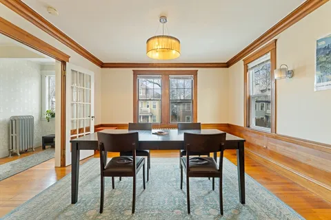 a hallway with a table and a refrigerator