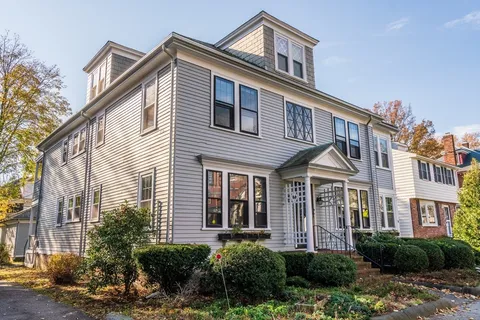 a front view of a house with plants and entryway