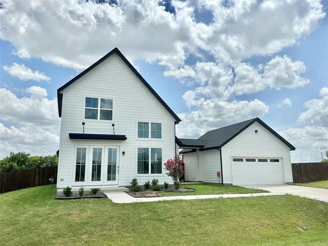 a view of a house with a yard and fence